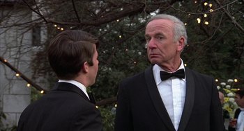 Movie still from “Hair” (1979), directed by Milos Forman – A man in a tuxedo and a man in a suit and bow tie; Close Up shot, Over the shoulder angle