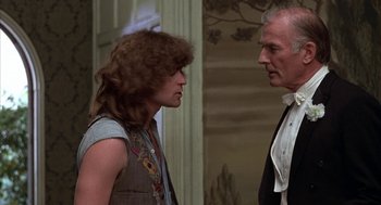 Movie still from “Hair” (1979), directed by Milos Forman – A man and a woman standing next to each other in a room; Medium shot, Over the shoulder angle