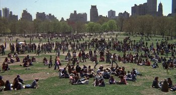 Movie still from “Hair” (1979), directed by Milos Forman – A crowd of people sitting on the grass in a park; Extreme Wide shot, High angle