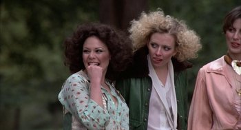 Movie still from “Hair” (1979), directed by Milos Forman – Two women walking and talking to each other outside; Medium shot, Low angle
