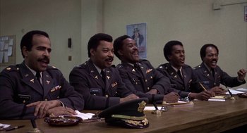 Movie still from “Hair” (1979), directed by Milos Forman – A group of men sitting at a table wearing uniforms; Medium shot, High angle