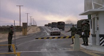 Movie still from “Hair” (1979), directed by Milos Forman – A road closed off with a black and yellow sign; Wide shot, High angle