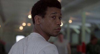 Movie still from “Hair” (1979), directed by Milos Forman – A person wearing a white t - shirt; Close Up shot, Low angle