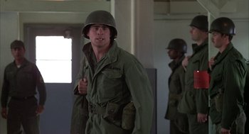 Movie still from “Hair” (1979), directed by Milos Forman – A man in a military uniform is giving a thumbs up; Medium shot, Low angle