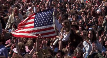 Movie still from “Hair” (1979), directed by Milos Forman – A crowd of people are gathered in a stadium to watch a concert; Wide shot, High angle