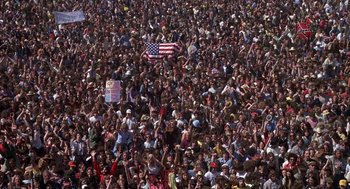 Movie still from “Hair” (1979), directed by Milos Forman – A large crowd of people gathered in the street; Extreme Wide shot, High angle