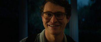 Movie still from “Halloween Ends” (2022), directed by David Gordon Green – A person wearing glasses and smiling; Close Up shot, Low angle