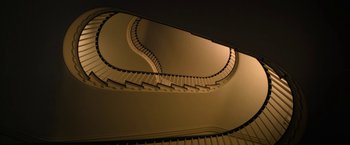 Movie still from “Halloween Ends” (2022), directed by David Gordon Green – A very long spiral staircase in a very dark room; Extreme Wide shot, High angle