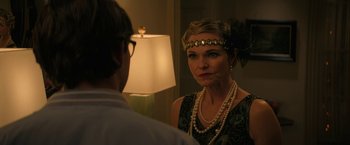 Movie still from “Halloween Ends” (2022), directed by David Gordon Green – A woman wearing a necklace and a feather headpiece; Close Up shot, Over the shoulder angle