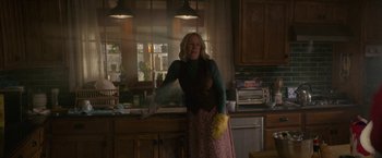 Movie still from “Halloween Ends” (2022), directed by David Gordon Green – A woman standing in a kitchen holding a banana; Medium shot, Low angle