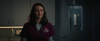 Movie still from “Halloween Ends” (2022), directed by David Gordon Green – A woman standing in front of a door wearing a red shirt; Close Up shot, Over the shoulder angle