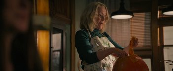 Movie still from “Halloween Ends” (2022), directed by David Gordon Green – An older woman wearing glasses and an apron; Medium shot, Low angle