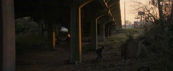 Movie still from “Halloween Ends” (2022), directed by David Gordon Green – A person riding a bicycle under a bridge; Extreme Wide shot, Low angle