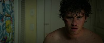 Movie still from “Halloween Ends” (2022), directed by David Gordon Green – A young man with bruises on his face; Close Up shot, Low angle