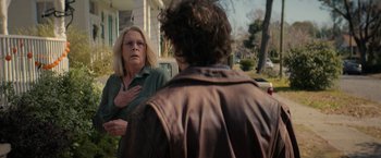 Movie still from “Halloween Ends” (2022), directed by David Gordon Green – A woman standing next to a man in a brown jacket; Medium shot, Over the shoulder angle