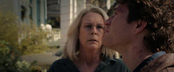 Movie still from “Halloween Ends” (2022), directed by David Gordon Green – An older woman and a younger man are kissing; Close Up shot, Over the shoulder angle