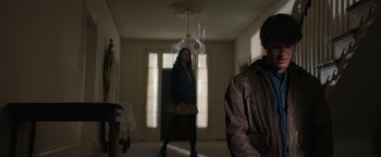 Movie still from “Halloween Ends” (2022), directed by David Gordon Green – Two people standing in a living room in front of a window; Medium shot, Low angle