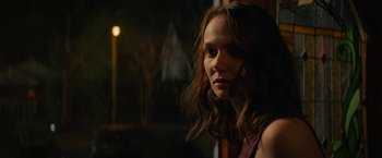 Movie still from “Halloween Ends” (2022), directed by David Gordon Green – A woman with long brown hair looking out a window; Close Up shot, Over the shoulder angle
