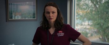 Movie still from “Halloween Ends” (2022), directed by David Gordon Green – A woman in a red shirt is standing in a room; Close Up shot, Over the shoulder angle