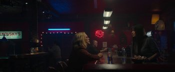 Movie still from “Halloween Ends” (2022), directed by David Gordon Green – A woman sitting at a bar with a man standing next to her; Wide shot, Over the shoulder angle