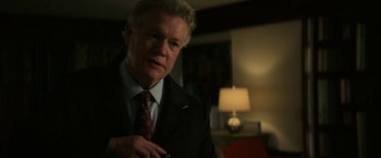 Movie still from “Halloween Ends” (2022), directed by David Gordon Green – An older man wearing a suit and tie; Close Up shot, Over the shoulder angle