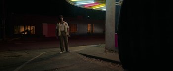 Movie still from “Halloween Ends” (2022), directed by David Gordon Green – A man standing on the side of the street at night; Wide shot, Low angle
