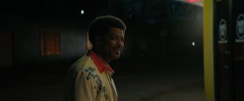 Movie still from “Halloween Ends” (2022), directed by David Gordon Green – A man in a yellow and red jacket is smiling; Close Up shot, Over the shoulder angle
