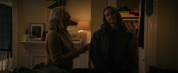 Movie still from “Halloween Ends” (2022), directed by David Gordon Green – Two people standing next to each other in a living room; Medium shot, Over the shoulder angle