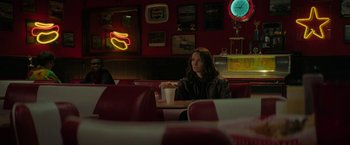 Movie still from “Halloween Ends” (2022), directed by David Gordon Green – A woman sitting at a table in a restaurant; Medium shot, Over the shoulder angle