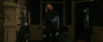 Movie still from “Halloween Ends” (2022), directed by David Gordon Green – A woman holding an umbrella in a dark room; Medium shot, Over the shoulder angle