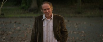 Movie still from “Halloween Ends” (2022), directed by David Gordon Green – An older man wearing a brown jacket and a striped shirt; Medium shot, Low angle