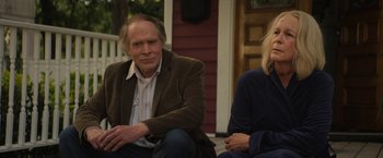 Movie still from “Halloween Ends” (2022), directed by David Gordon Green – A man and a woman sitting on the porch of a house; Medium shot, Over the shoulder angle