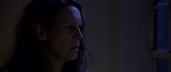 Movie still from “Halloween: Resurrection” (2002), directed by Rick Rosenthal – A woman with long black hair looking to her left; Close Up shot, Low angle