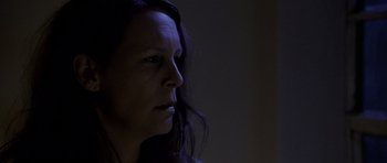 Movie still from “Halloween: Resurrection” (2002), directed by Rick Rosenthal – A woman with long dark hair looking to her left; Close Up shot, Low angle