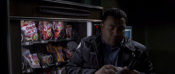 Movie still from “Halloween: Resurrection” (2002), directed by Rick Rosenthal – A man sitting in front of an open vending machine; Medium shot, High angle