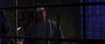 Movie still from “Halloween: Resurrection” (2002), directed by Rick Rosenthal – A man with red hair and a red wig is standing in front of a jail cell; Close Up shot, Over the shoulder angle