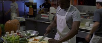 Movie still from “Halloween: Resurrection” (2002), directed by Rick Rosenthal – A man in an apron cutting vegetables on a cutting board; Medium shot, High angle