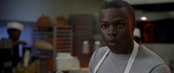Movie still from “Halloween: Resurrection” (2002), directed by Rick Rosenthal – A man in a gray shirt is looking at the camera; Close Up shot, Over the shoulder angle