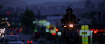 Movie still from “Halloween: Resurrection” (2002), directed by Rick Rosenthal – A person riding a motorcycle on a street at night; Wide shot, Low angle