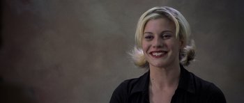 Movie still from “Halloween: Resurrection” (2002), directed by Rick Rosenthal – A woman with blonde hair smiling for the camera; Close Up shot, Over the shoulder angle
