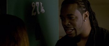 Movie still from “Halloween: Resurrection” (2002), directed by Rick Rosenthal – A person smiling near a green wall; Close Up shot, Over the shoulder angle