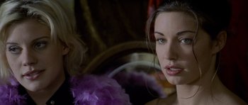 Movie still from “Halloween: Resurrection” (2002), directed by Rick Rosenthal – A person wearing a purple feather boa; Close Up shot, Over the shoulder angle