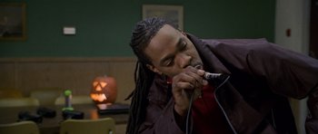 Movie still from “Halloween: Resurrection” (2002), directed by Rick Rosenthal – A man with dreadlocks is holding a microphone; Close Up shot, High angle
