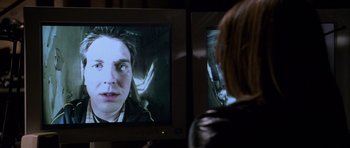 Movie still from “Halloween: Resurrection” (2002), directed by Rick Rosenthal – A woman is watching a television screen with a man on it; Close Up shot, Over the shoulder angle