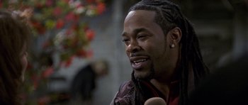 Movie still from “Halloween: Resurrection” (2002), directed by Rick Rosenthal – A person with dreadlocks talking to a microphone; Close Up shot, Over the shoulder angle