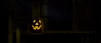 Movie still from “Halloween: Resurrection” (2002), directed by Rick Rosenthal – A jack - o - lantern that is lit up; Extreme Close Up shot, High angle