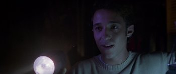 Movie still from “Halloween: Resurrection” (2002), directed by Rick Rosenthal – A young man holding a flashlight in a dark room; Close Up shot, Over the shoulder angle