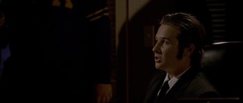 Movie still from “Halloween: Resurrection” (2002), directed by Rick Rosenthal – A man in a suit and tie looking up at something; Close Up shot, Over the shoulder angle