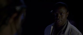 Movie still from “Halloween: Resurrection” (2002), directed by Rick Rosenthal – A man in a white shirt is standing in the dark; Close Up shot, Over the shoulder angle