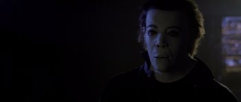 Movie still from “Halloween: Resurrection” (2002), directed by Rick Rosenthal – A person with a mask is standing in the dark; Close Up shot, Low angle